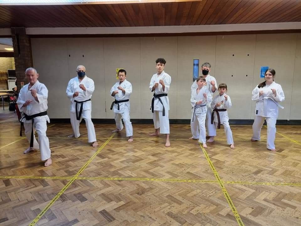 Adults dressed in karate suits in a guard pose
